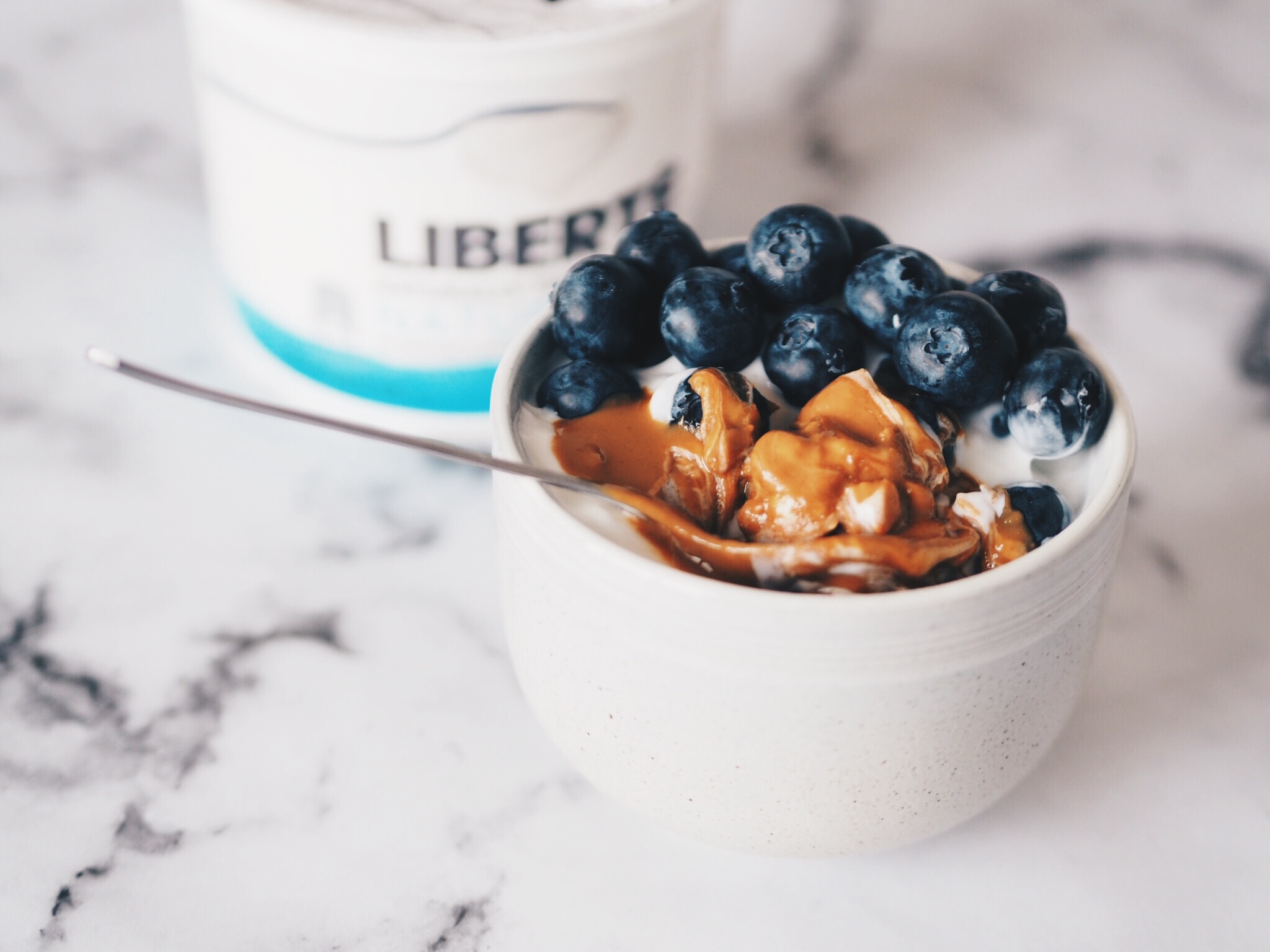 Liberte yogurt in bowl with peanut butter and blueberries