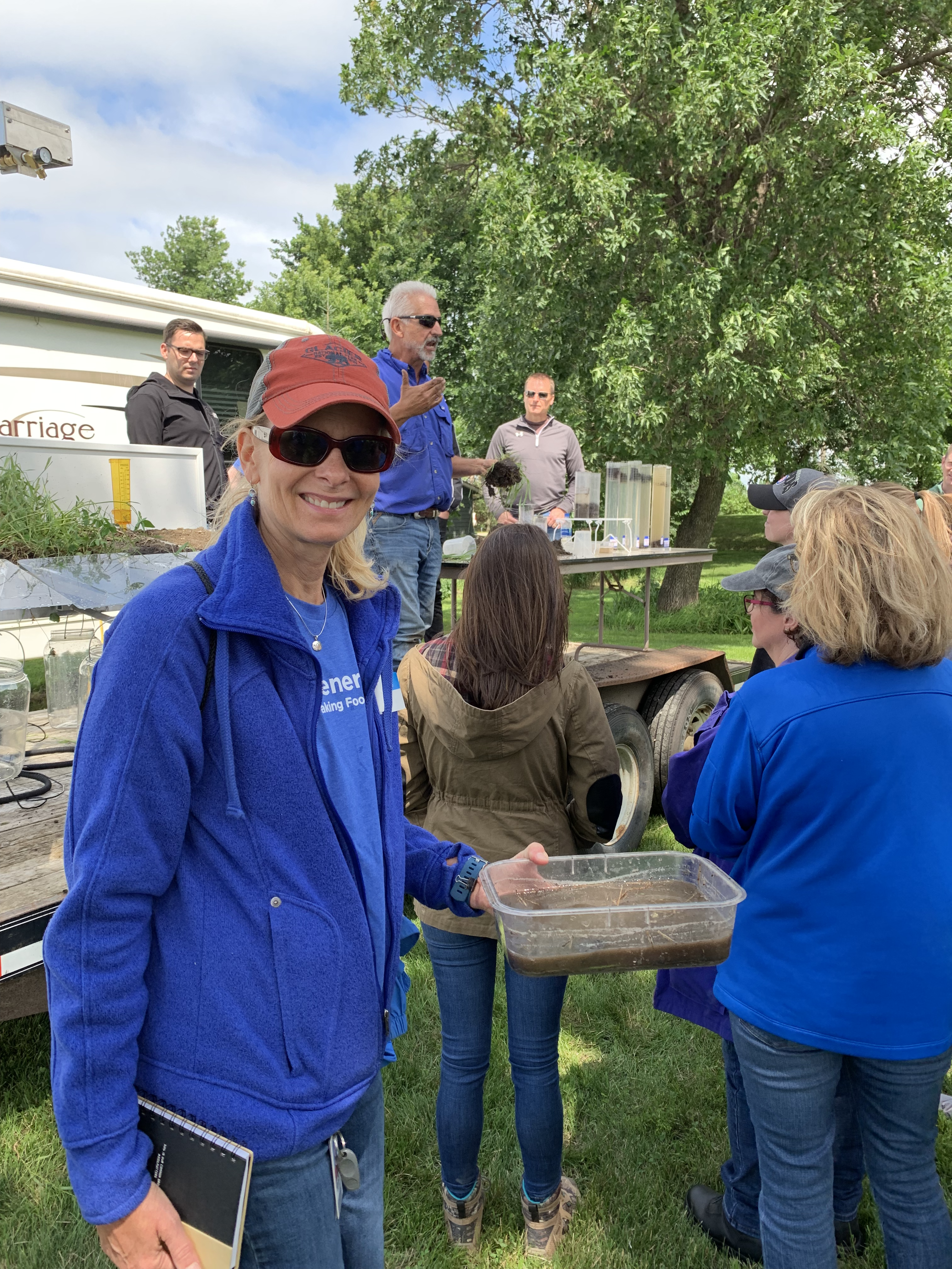 Female employee smiling during soil demonstration