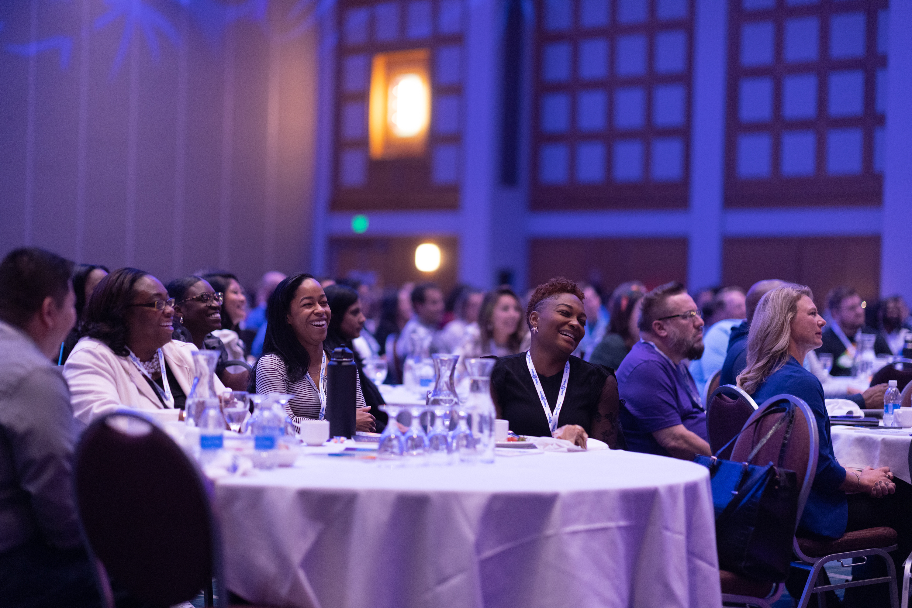 Employees smiling at the stage during the Employee Network Summit