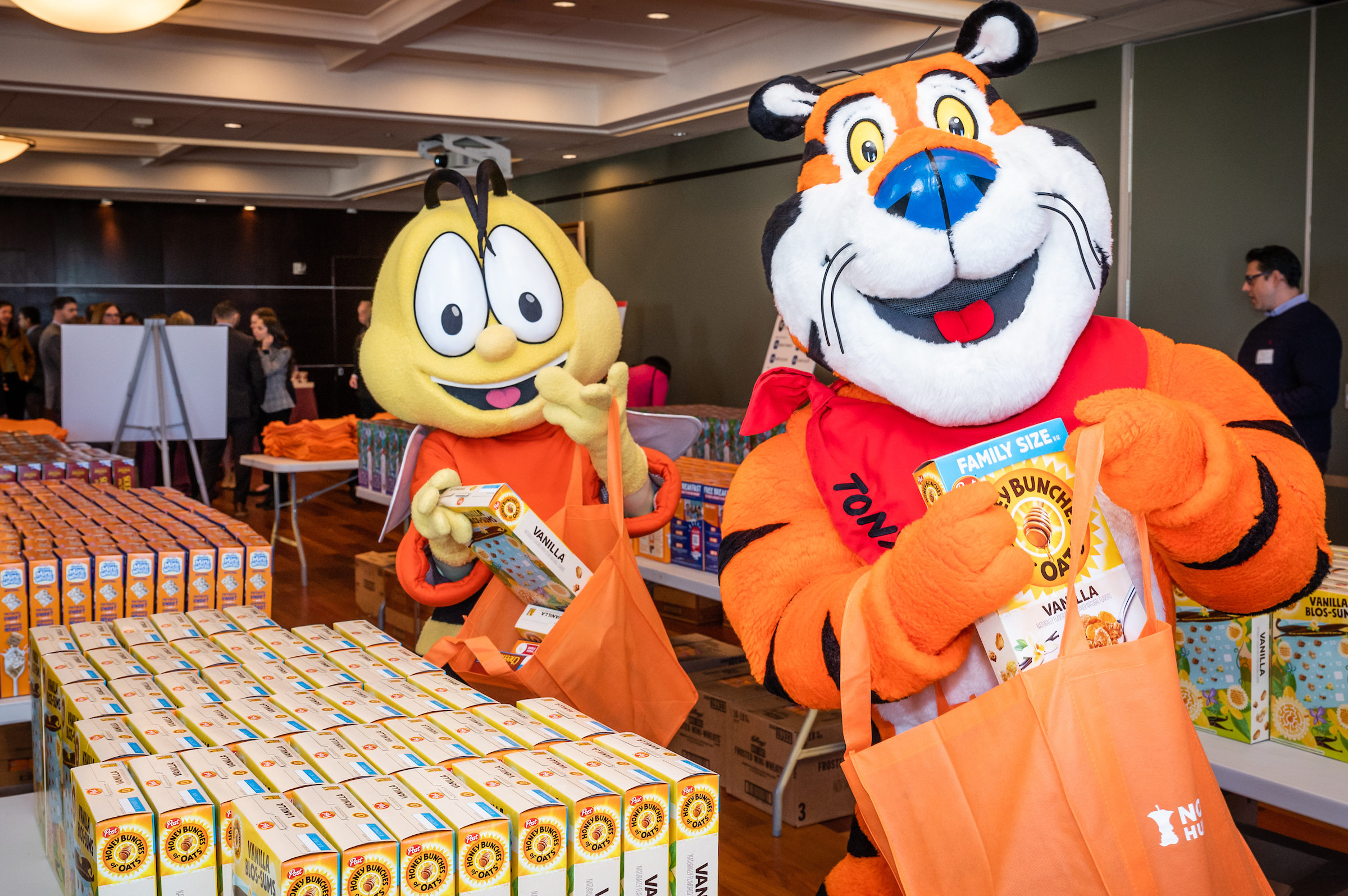 Buzz Bee and Tony the Tiger packing cereal boxes for hunger relief organizations