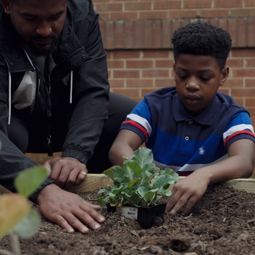 Oakland Elementary Student Planting in the Garden