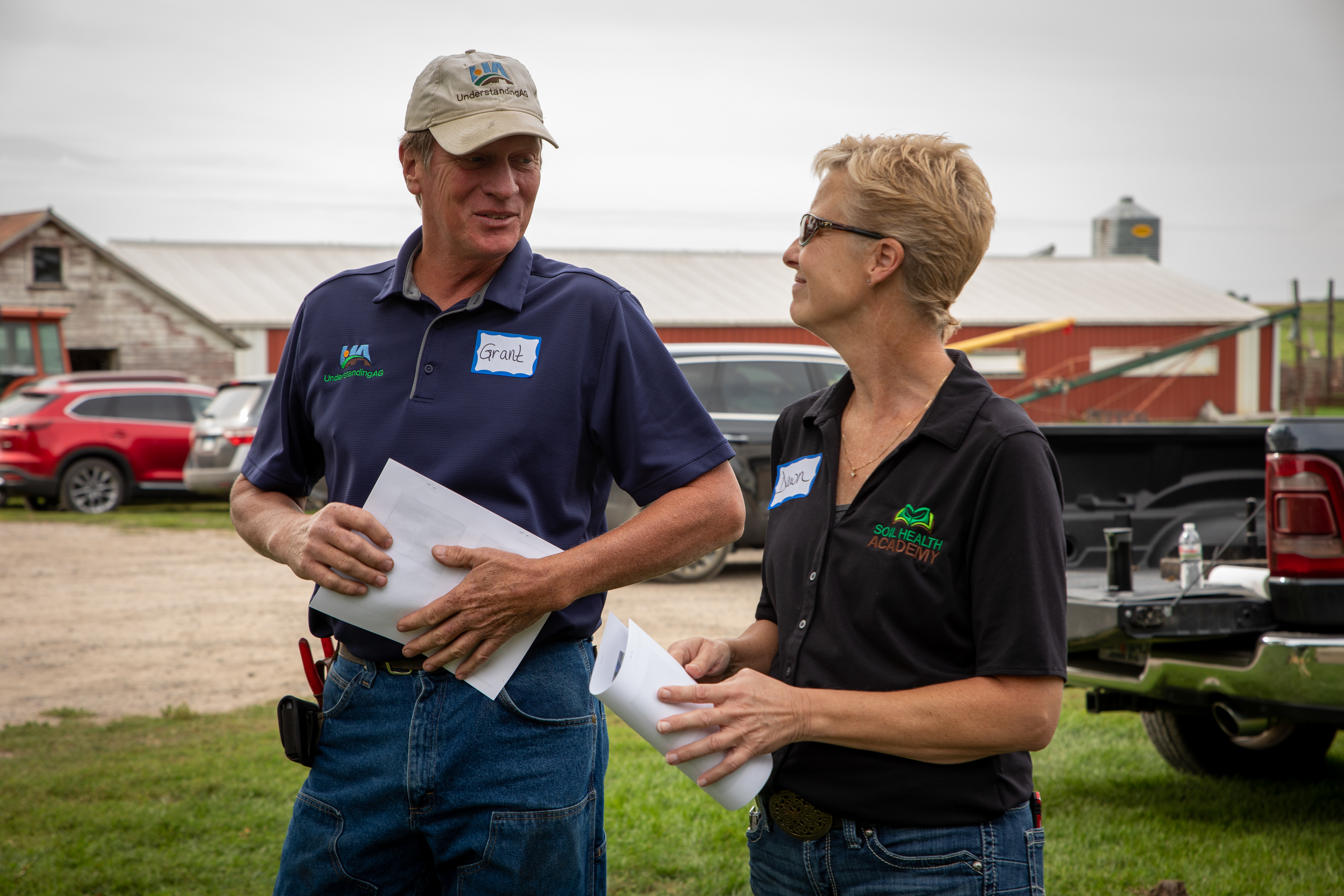Man and woman talking at farm, holding papers