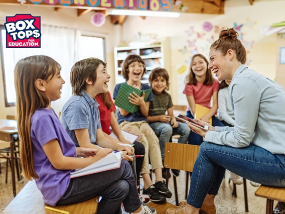 Groups of students laughing with their teacher.